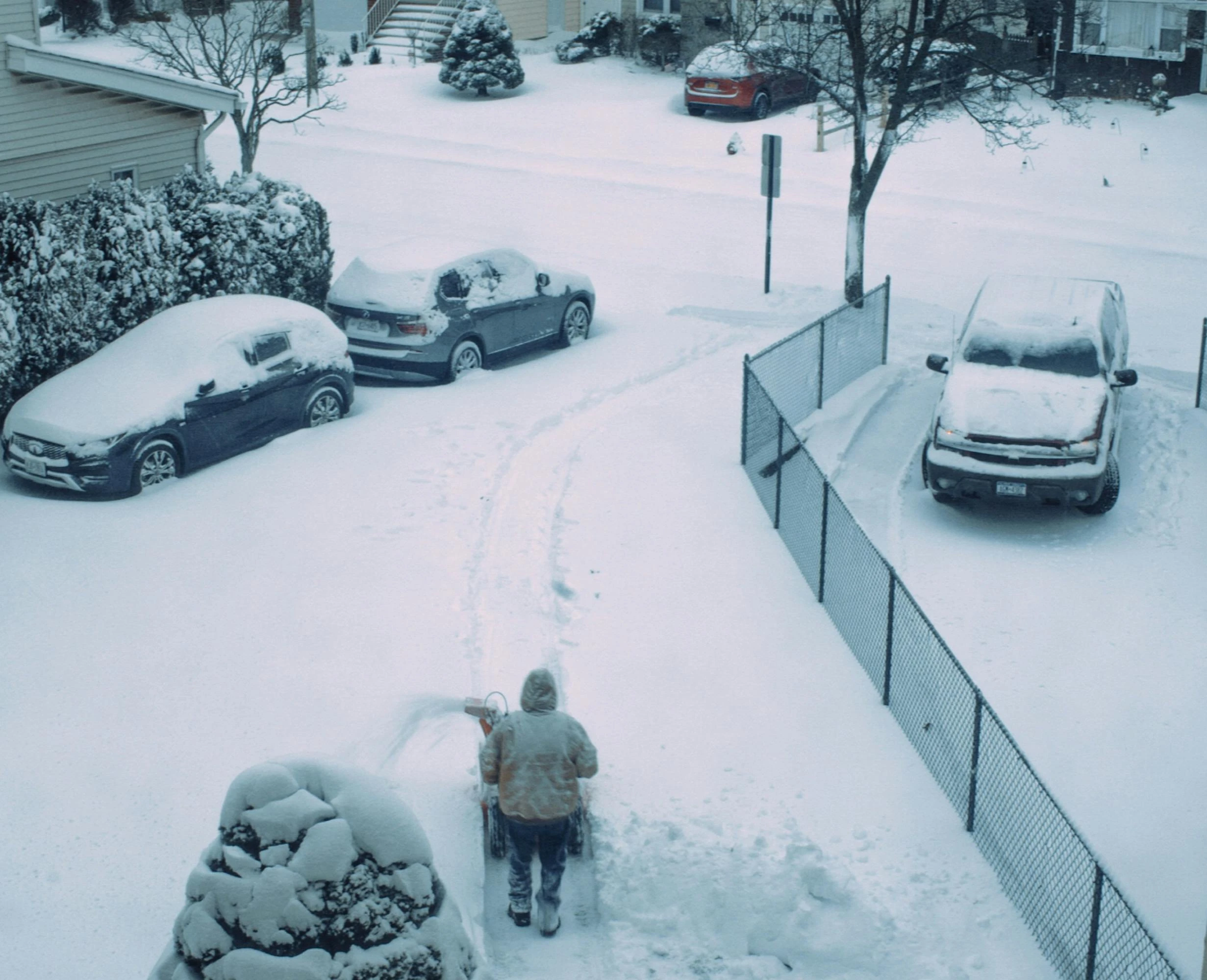 Clean driveway after a snowfall with a snowy residential background